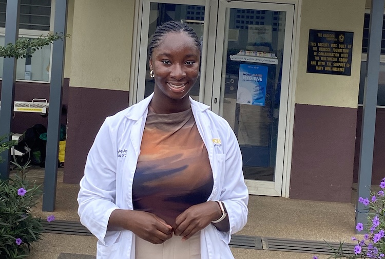 Michelle Johnson, a Pharm.D. student, stands in front of a clinic in Ghana