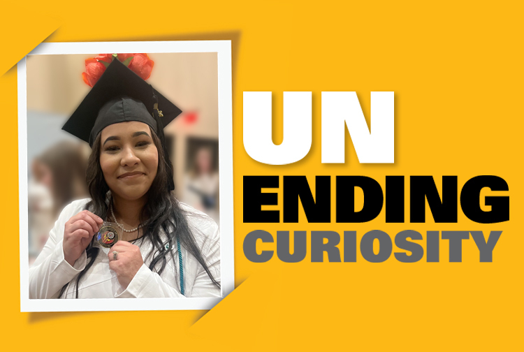 Woman graduating from college holds up a challenge coin, the words unending curiosity are next to her